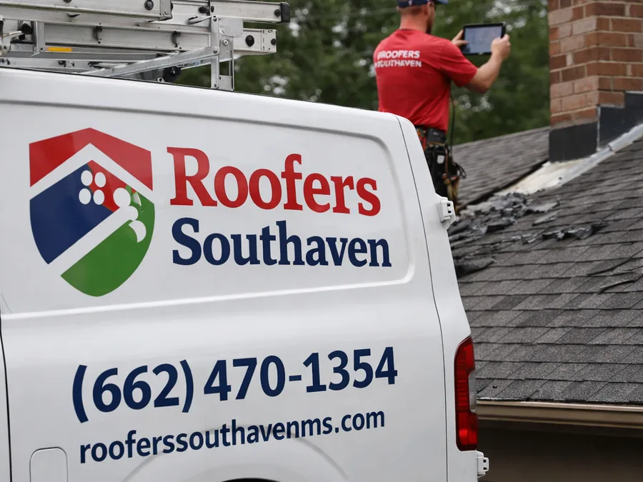 Roofer photographing chimney flashing and inspecting shingles for storm damage